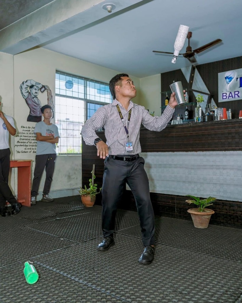 Student practicing live flair tossing with bottles and shakers